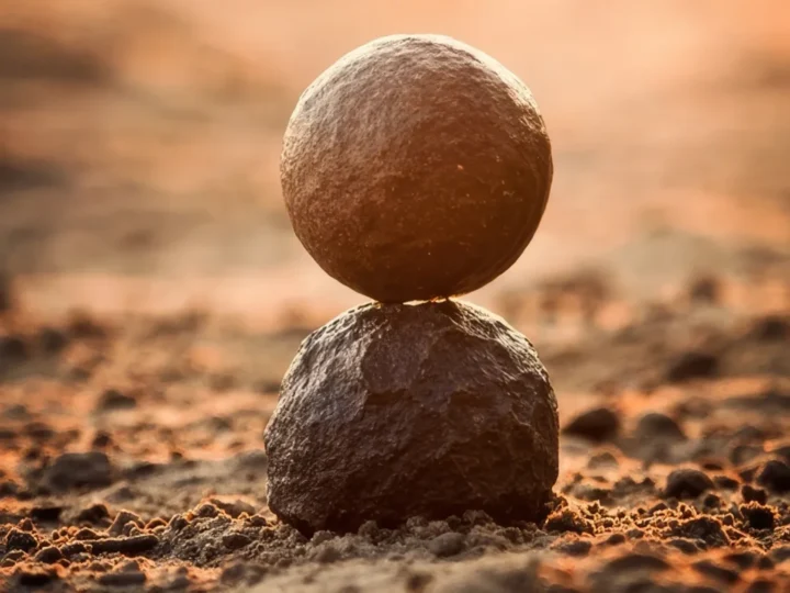 Zwei runde Steine stehen in Balance aufeinander